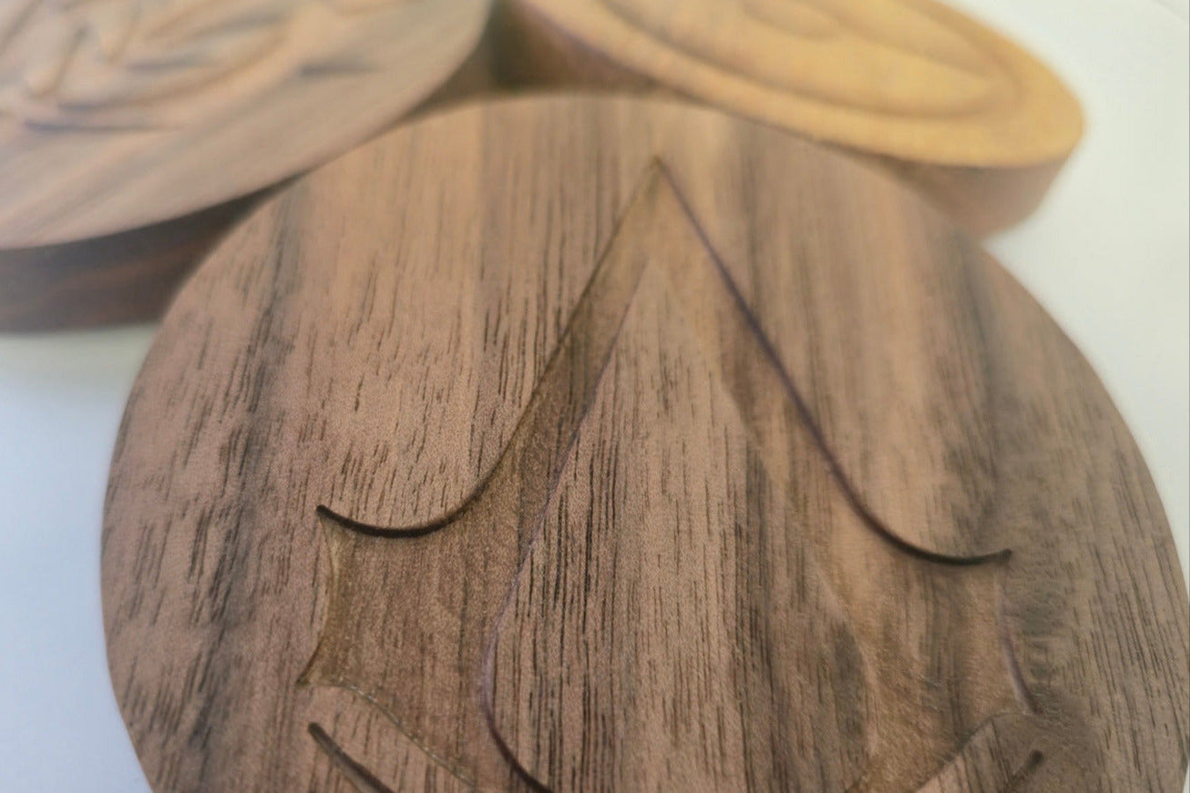Wooden coasters with leaf design on a white surface